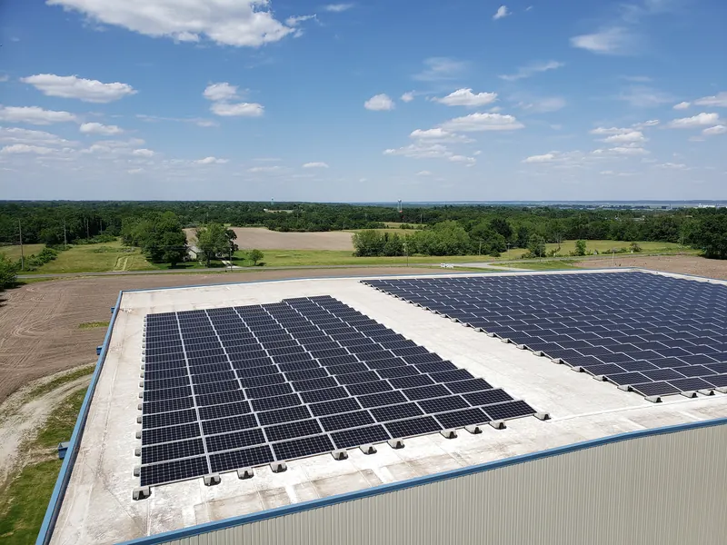 Aerial view of a flat commercial roof covered with rows of solar panels