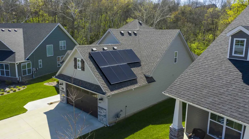 Suburban home with a solar array on the roof above the garage