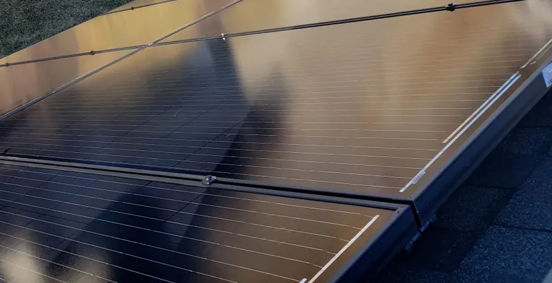 Close-up of dark solar panels reflecting the sky